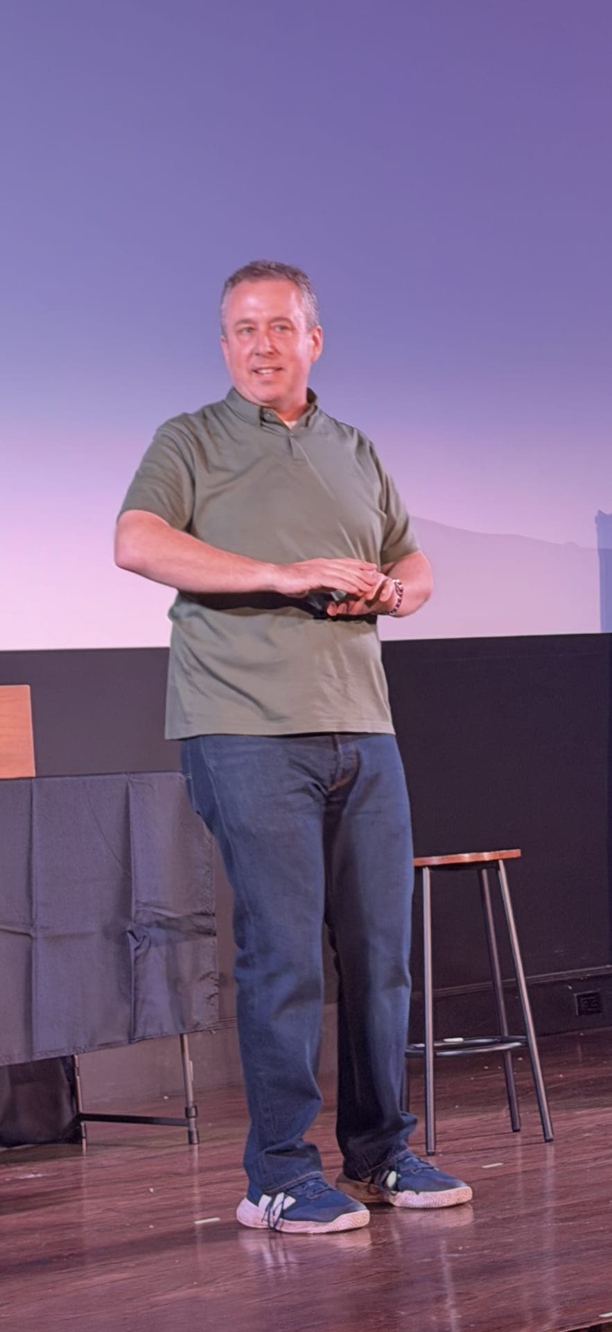 Mayor Chance Mullen standing on stage in a green polo shirt and jeans.